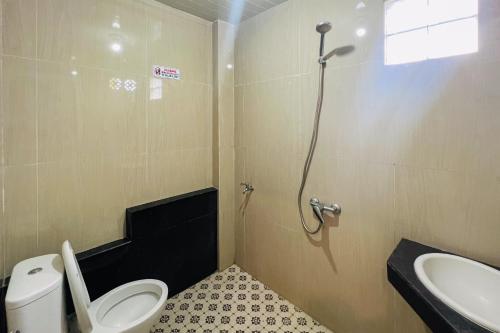 a bathroom with a toilet and a sink at Teratai Residence Mitra RedDoorz in Medan