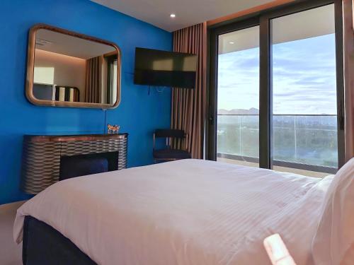 a bedroom with a large white bed and a mirror at Mullet Bay Suites - Your Luxury Stay Awaits in Cupecoy