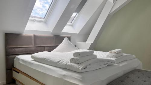 a white bed with towels on top of it at New Nomads Ferienwohnung am See in Zossen