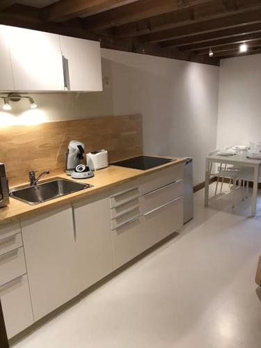 - une cuisine avec des placards blancs, un évier et une table dans l'établissement Studio 30m2 centre de Cusset, à Cusset