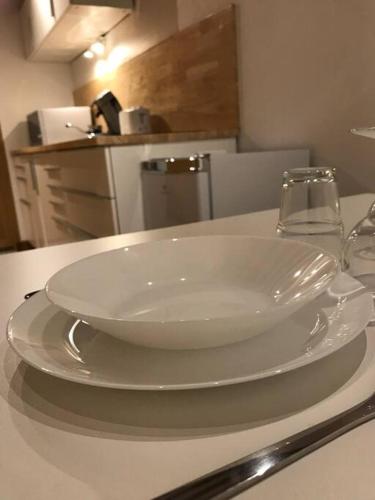 uma tigela branca num prato numa mesa com um copo em Studio 30m2 centre de Cusset em Cusset