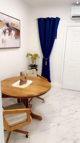a room with a wooden table and a blue curtain at Guest House , 5 min away from LAS Airport. in Las Vegas