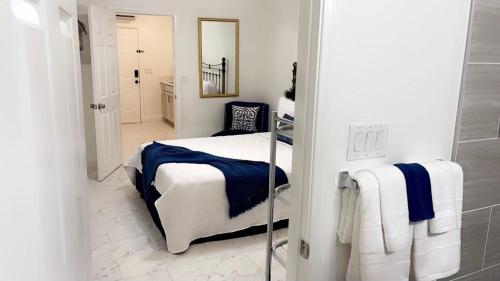Habitación blanca con cama y espejo en Guest House , 5 min away from LAS Airport. en Las Vegas
