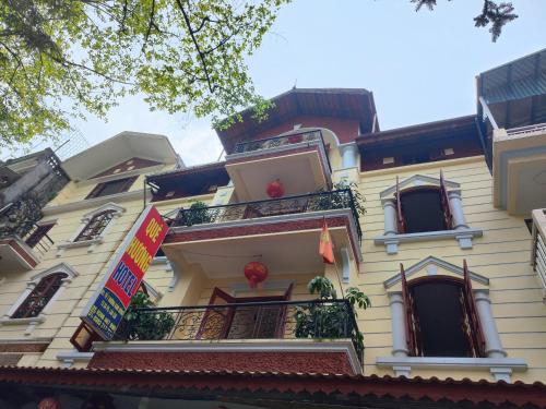 a tall yellow building with balconies and windows at Quê Hương house in Sa Pa