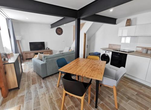Il dispose d'une cuisine et d'un salon avec une table et des chaises en bois. dans l'établissement Les remparts de Caroline, au pied de La Cité., à Carcassonne
