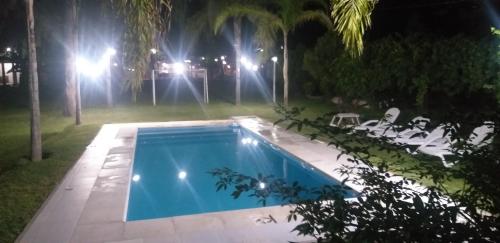 a swimming pool in a yard at night at Cabañas TERMALES in Termas de Río Hondo