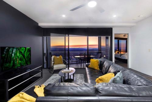 a living room with a leather couch and a television at Circle on Cavill - Self Contained & Privately Managed - Wow Stay in Gold Coast