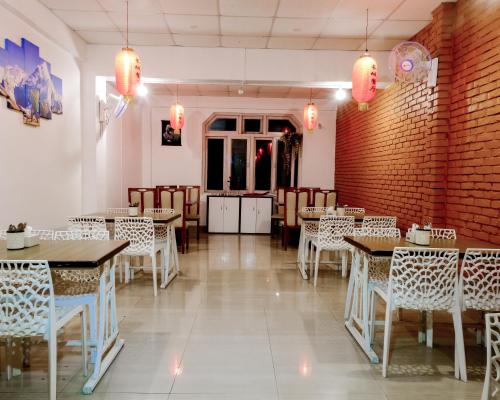 un restaurante con mesas, sillas y paredes de ladrillo rojo en Happy Days Inn, en Pokhara