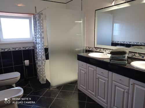 a bathroom with a toilet and two sinks and a window at chez Sylvie et Alain in Lamas