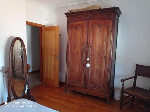 a wooden cabinet in a room with a mirror at chez Sylvie et Alain 