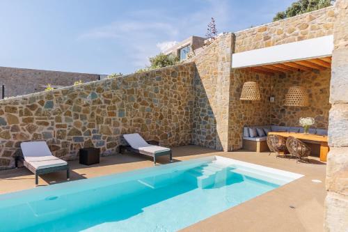 a pool with two chairs and a stone wall at Luxusvilla Lagoon 4 Personen privater Pool in Gialova