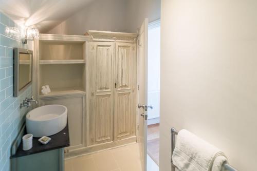 a bathroom with a sink and a wooden cabinet at Kittiwake Cottage in Braunton