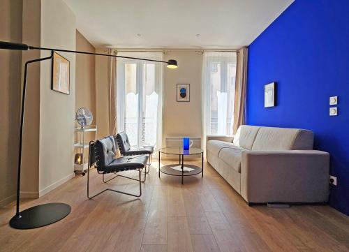 un salon avec un canapé et un mur bleu dans l'établissement La Grande Bleue - Appartement confortable à deux pas du Panier, à Marseille