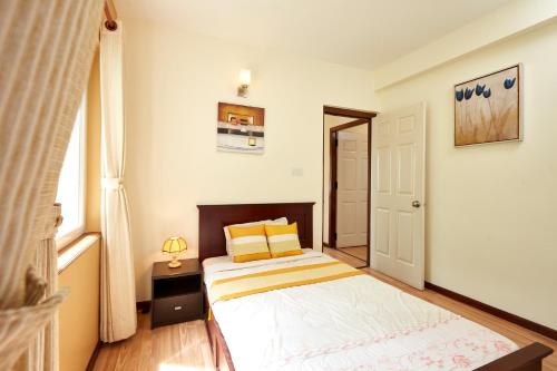a small bedroom with a bed and a window at Swayambhu Hotels & Apartments- Sitapaila in Kathmandu