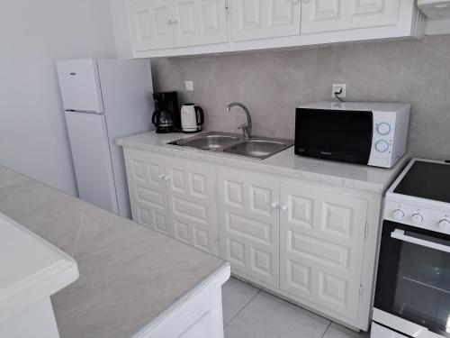 a kitchen with a sink and a microwave at Anixi - Primavera Mykonos in Ornos