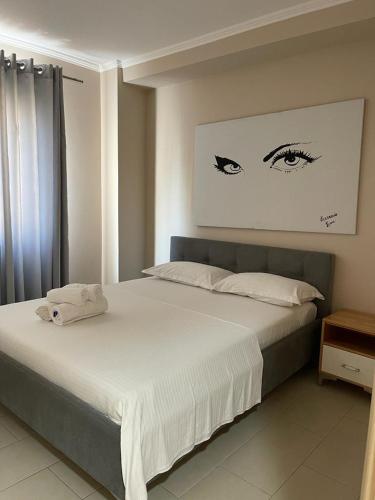 1 dormitorio con 1 cama grande con sábanas blancas en Hotel Adria, en Shëngjin