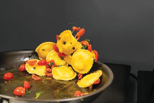 a plate of food with yellow pasta and vegetables at Adesso Hotel in Rome