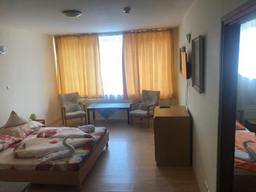 a hotel room with a bed and a table and chairs at City Hotel Siófok in Siófok