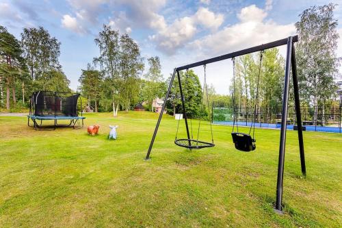 two animals standing in a field with a swing at Saunamäki - Luoto in Salo