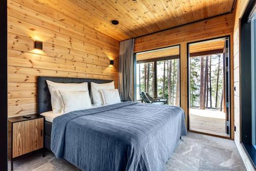 a bedroom with a bed in a wooden cabin at Saunamäki - Luoto in Salo