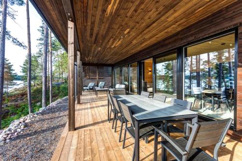 a wooden deck with a table and chairs on it at Saunamäki - Luoto in Salo