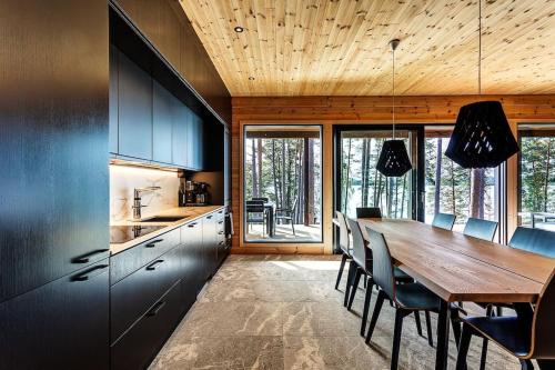 a kitchen with a long wooden table and chairs at Saunamäki - Luoto in Salo