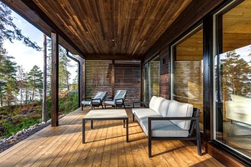 a screened porch with a couch and chairs on it at Saunamäki - Luoto in Salo