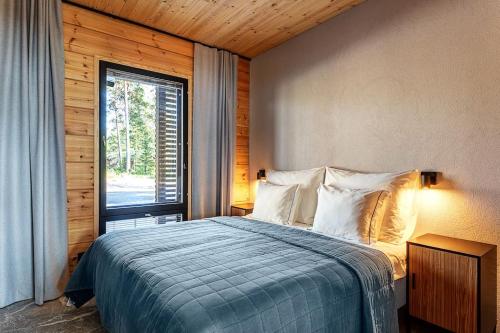 a bedroom with a bed and a large window at Saunamäki - Luoto in Salo