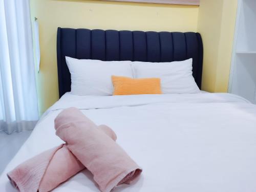 a stuffed animal is laying on a bed at Strait Garden Family Suites by Maj in Jelutong