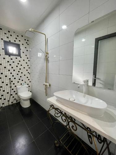 a white bathroom with a sink and a toilet at TRANG Homestay in Bao Loc