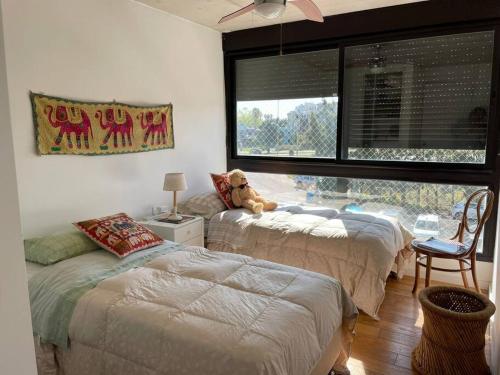 1 dormitorio con 2 camas y un osito de peluche en la cama en Precioso apartamento en moderno edificio, en Montevideo
