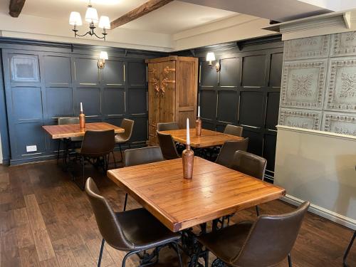 uma sala de jantar com mesas e cadeiras de madeira em New Inn Hotel em Clapham