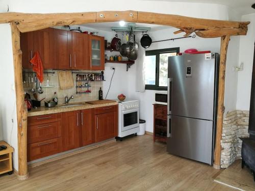 a kitchen with a stainless steel refrigerator and wooden cabinets at מצפה 1050 in Neve Ativ