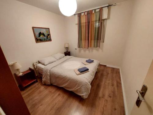 een kleine slaapkamer met een bed en houten vloeren bij מצפה 1050 in Neve Ativ