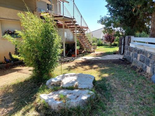 a house with a staircase in the yard at מצפה 1050 in Neve Ativ