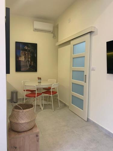 uma sala de jantar com uma mesa e cadeiras e uma porta em Sunlit artist studio em Belgrado