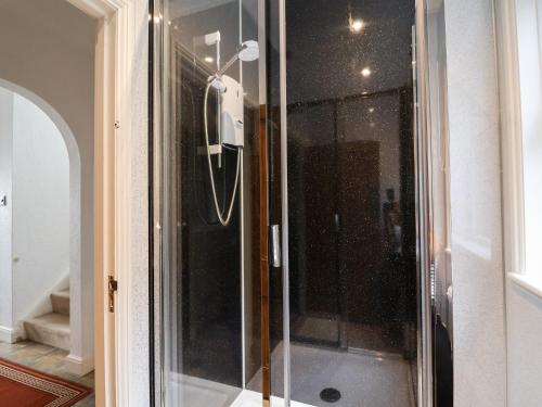 a glass shower with a phone in a room at The Pink House in Felixstowe