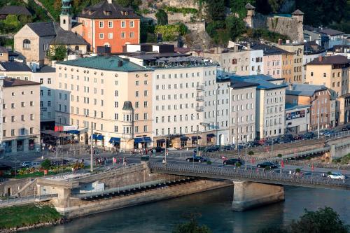 eine Brücke über einen Fluss in einer Stadt mit Gebäuden in der Unterkunft Hotel Stein - Adults Only in Salzburg