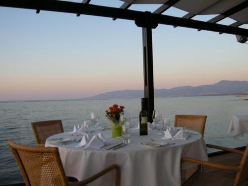 a table with a white table cloth and a bottle of wine at Souli Beach Hotel in Polis Chrysochous