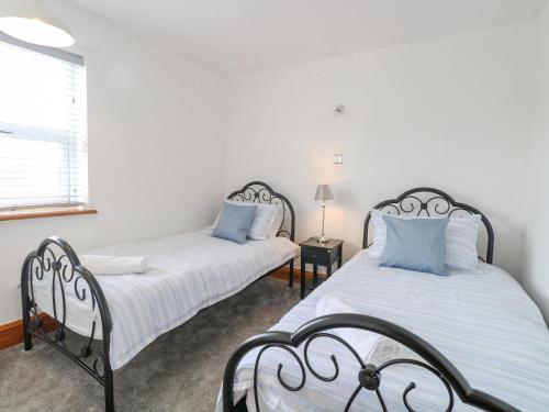 two beds sitting next to each other in a bedroom at Seashell Cottage in Lowestoft