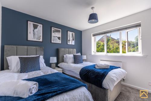 een slaapkamer met 2 bedden en een raam bij Cosy 5 bedroom house - Central By Valore Property Services in Loughton