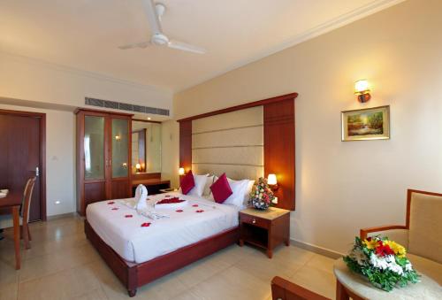 a bedroom with a bed and a desk and a chair at Cochin Palace in Cochin