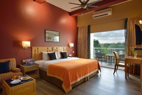 a hotel room with a bed and a balcony at Gir Serai - IHCL SeleQtions in Sasan Gir