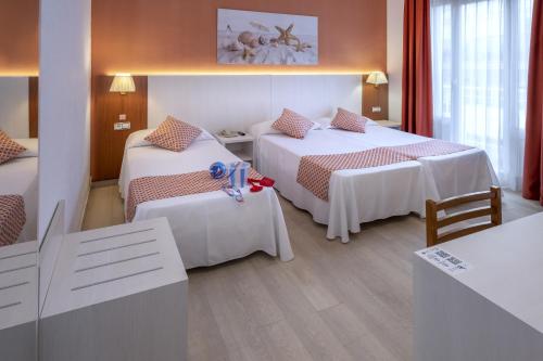 a hotel room with two beds and a table at GHT Balmes, Hotel-Aparthotel&SPLASH in Calella