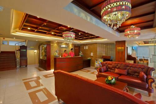 a lobby with a leather couch and a bar at Cochin Palace in Cochin