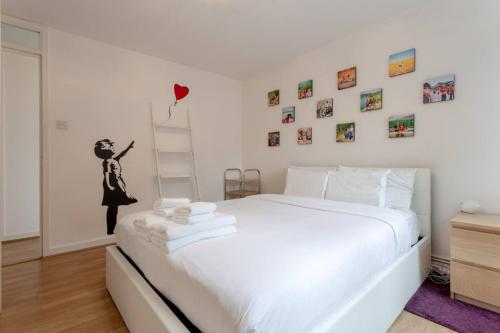 a white bedroom with a white bed and a ladder at Stylish 1 Bedroom Apartment Near Clapham Junction in London