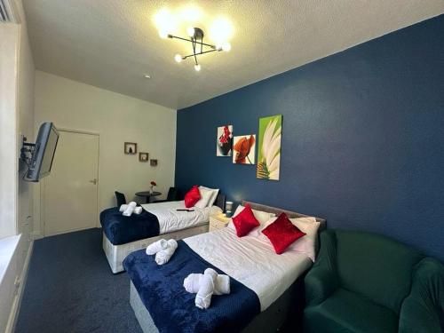 Habitación de hotel con 2 camas y sofá en A&A Luxury Stay Bettys en Pallion