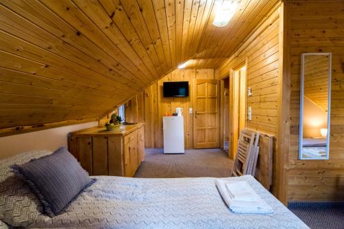 - une chambre avec un lit dans une cabane en bois dans l'établissement Tündérkert Apartman, à Debrecen