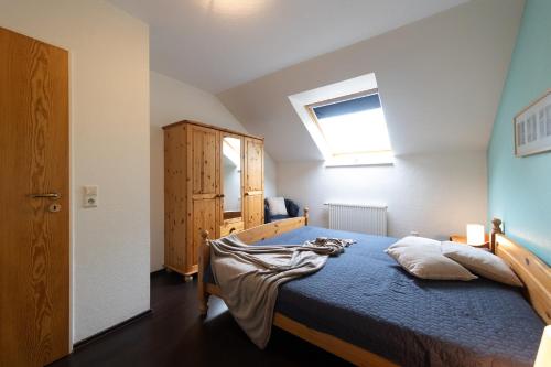 a bedroom with a bed with a blue comforter and a window at LM7-15 - Ferienwohnung Typ AB in Schottwarden