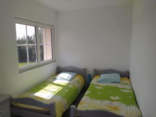2 camas en una habitación con ventana en Appart à la campagne en Marnefer